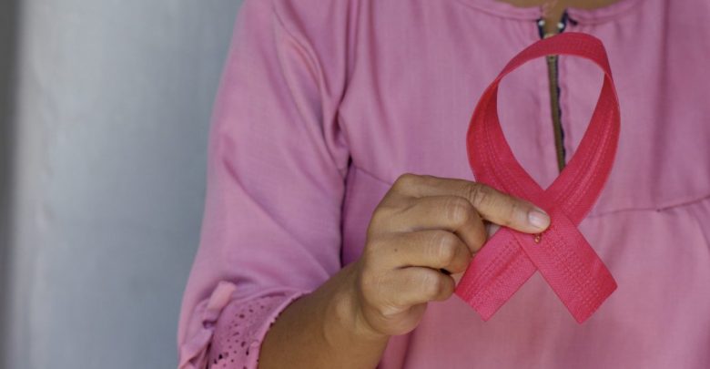 woman holding a pink ribbon