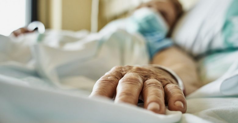 Patient in hospital wearing mask receiving IV medicine