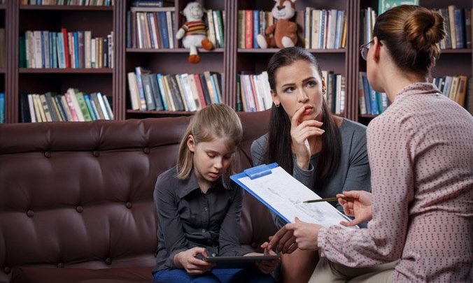 Three women: child, parent and doctor in office