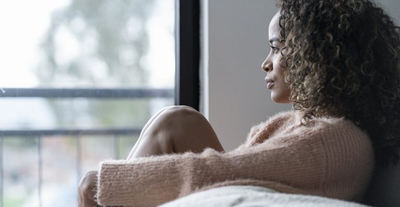 woman-sitting-in-the-living-room-of-her-house-looking-away