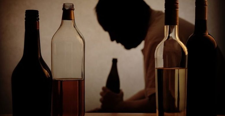 Alcohol bottles and person holding one of them