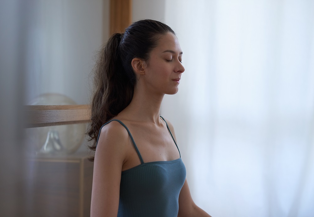 woman sitting on floor meditating